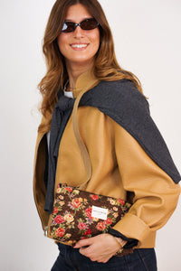 DE LA MUR Floral Jacquard Clutch held by model, front view with rose print