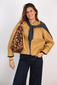 Model with the DE LA MUR floral jacquard Round Shoulder Bag in brown and red on her shoulder