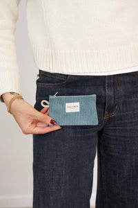 Model holding DE LA MUR teal corduroy coin purse at hip, lifestyle shot