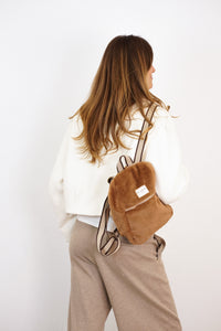 DE LA MUR Faux Fur Small Backpack in camel brown, worn on the back, lifestyle view