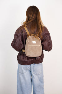 Model wearing the DE LA MUR Toast corduroy small backpack, back lifestyle view