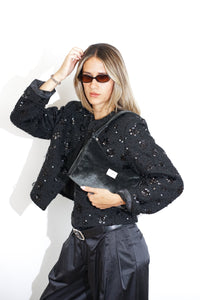 Model in sequin jacket with the DE LA MUR Small Evening Bag in black velvet on her shoulder