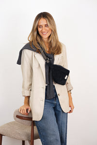Model wearing DE LA MUR black corduroy fanny pack crossbody