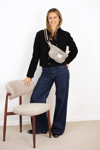 Model wearing DE LA MUR Koto leopard jacquard fanny pack crossbody, beige and black, lifestyle shot