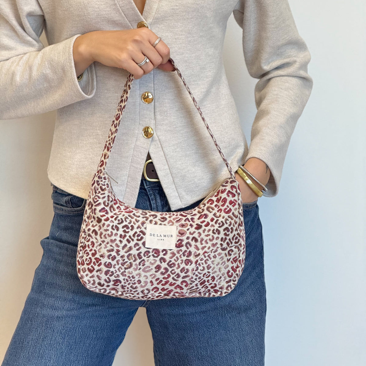 Model holding the DE LA MUR Talco animal print shoulder bag, lifestyle