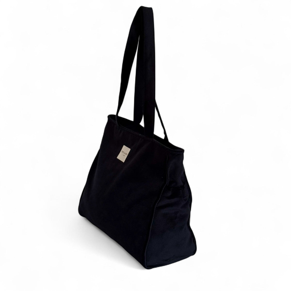 DE LA MUR black tote bag, three-quarter side view showing side pockets