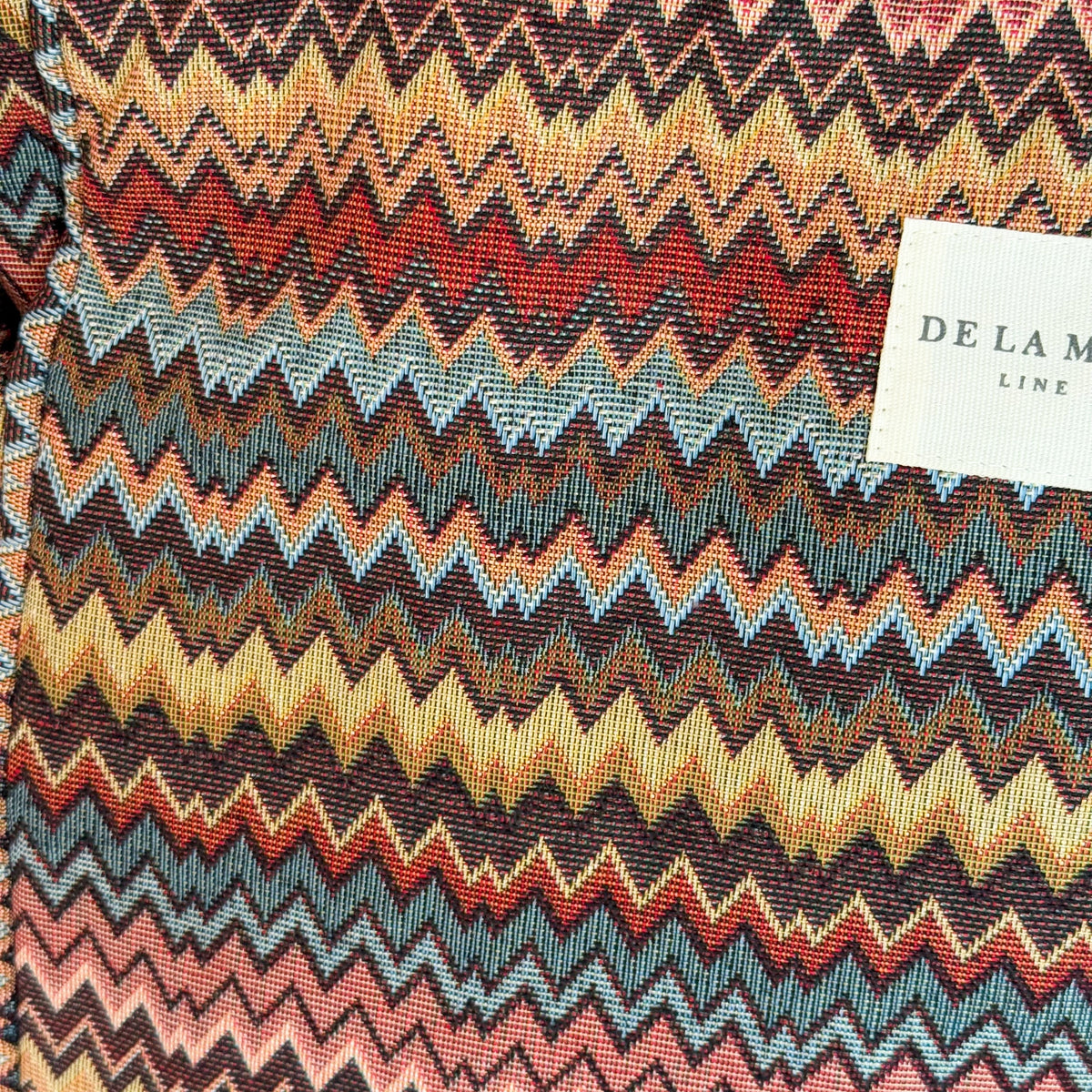 Close-up of the multicolor zigzag chevron jacquard fabric and DE LA MUR label