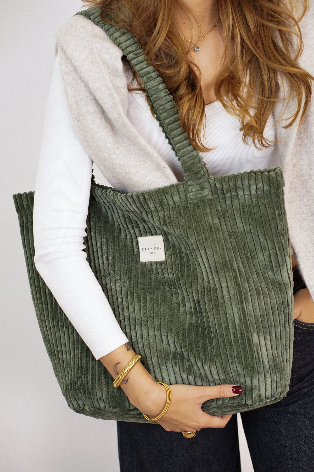 DE LA MUR Musgo olive green corduroy tote bag carried on the shoulder, lifestyle close-up