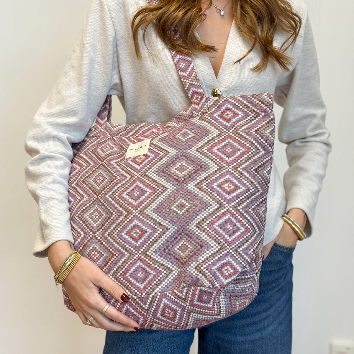 Model carrying the DE LA MUR Nana pink and lilac jacquard tote on the shoulder