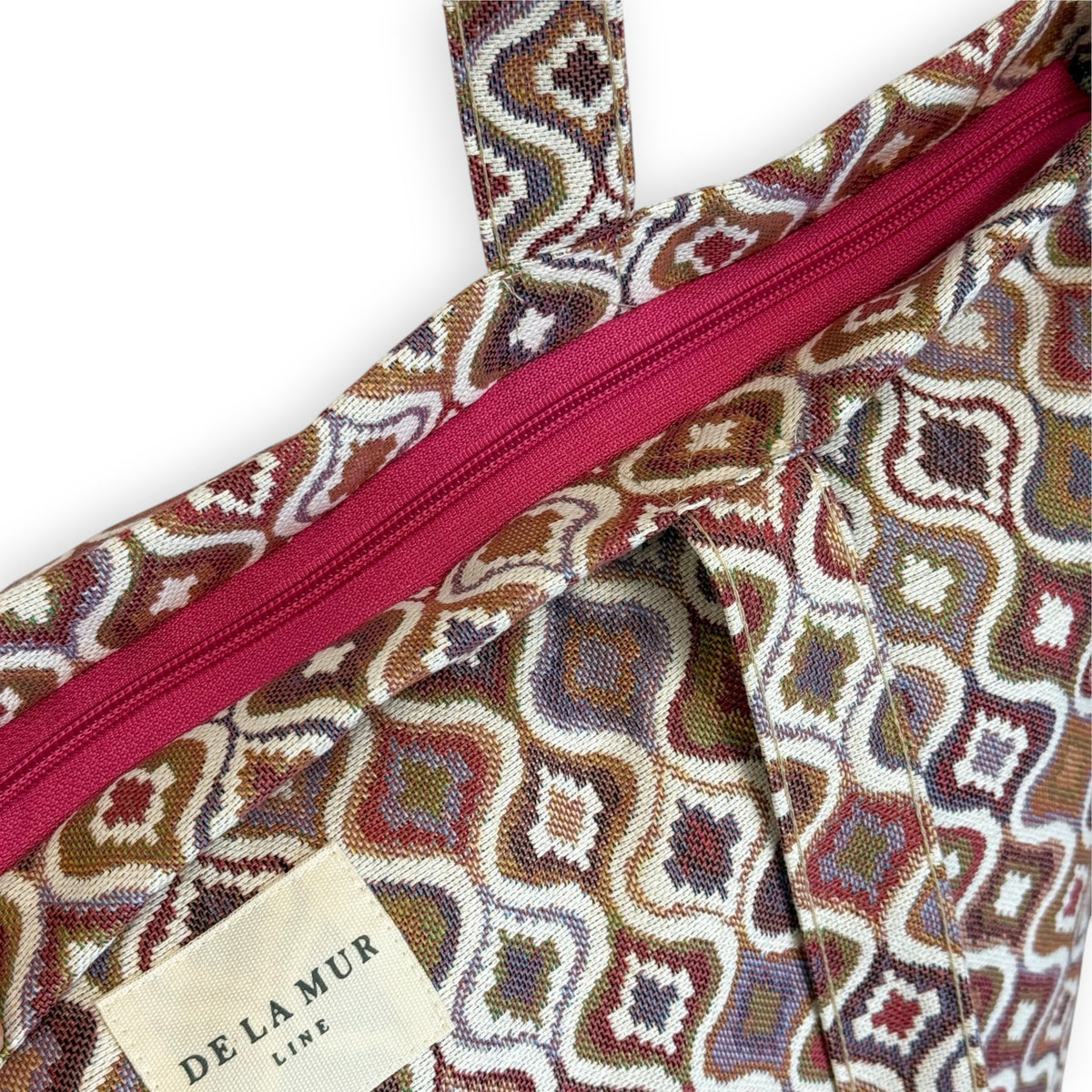 Close-up of the pink top zip and DE LA MUR Line label on the Onda jacquard tote