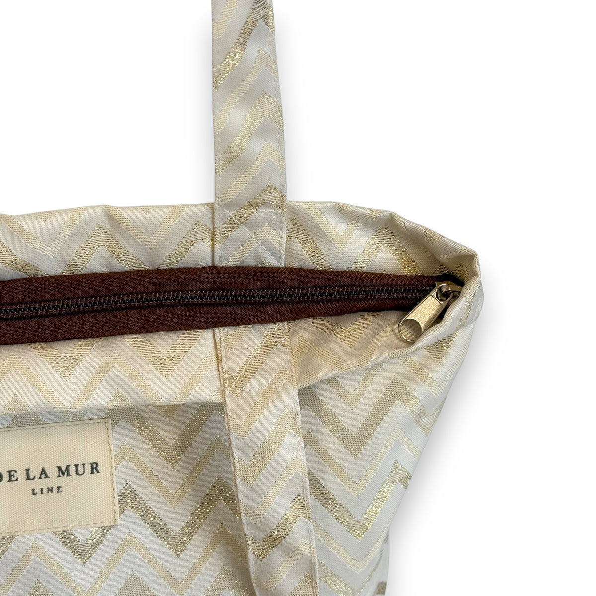 Open DE LA MUR zigzag bag showing zip closure and inner label