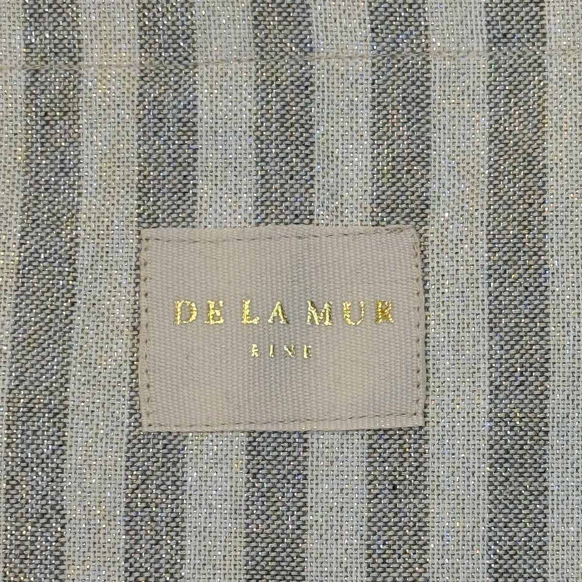 Detail of the gray striped lurex weave and DE LA MUR Line woven label