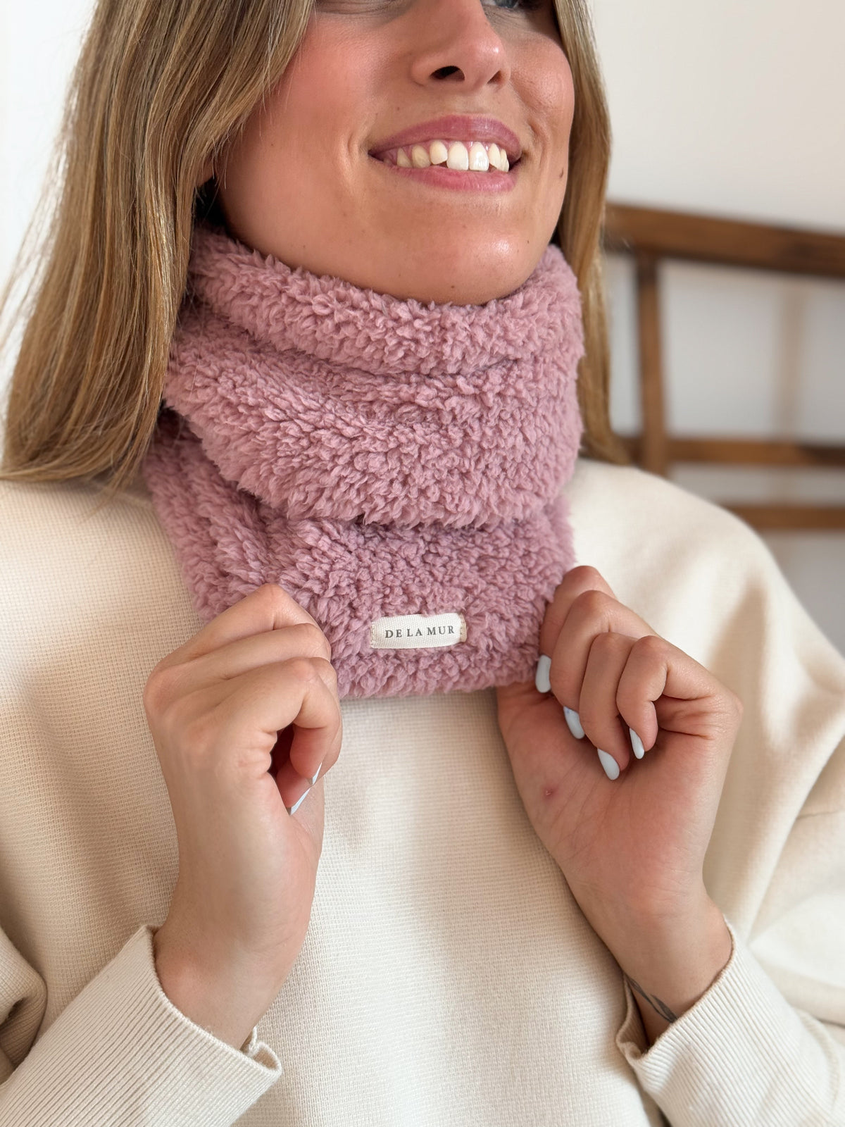 Close-up of the pink fleece texture and DE LA MUR label on the Kalt neck warmer