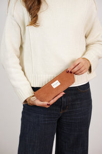Model holding the DE LA MUR terracotta corduroy pencil case