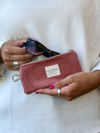 Model holding DE LA MUR coral corduroy glasses case with sunglasses