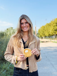 Model holding the DE LA MUR Taz mustard corduroy coin purse outdoors