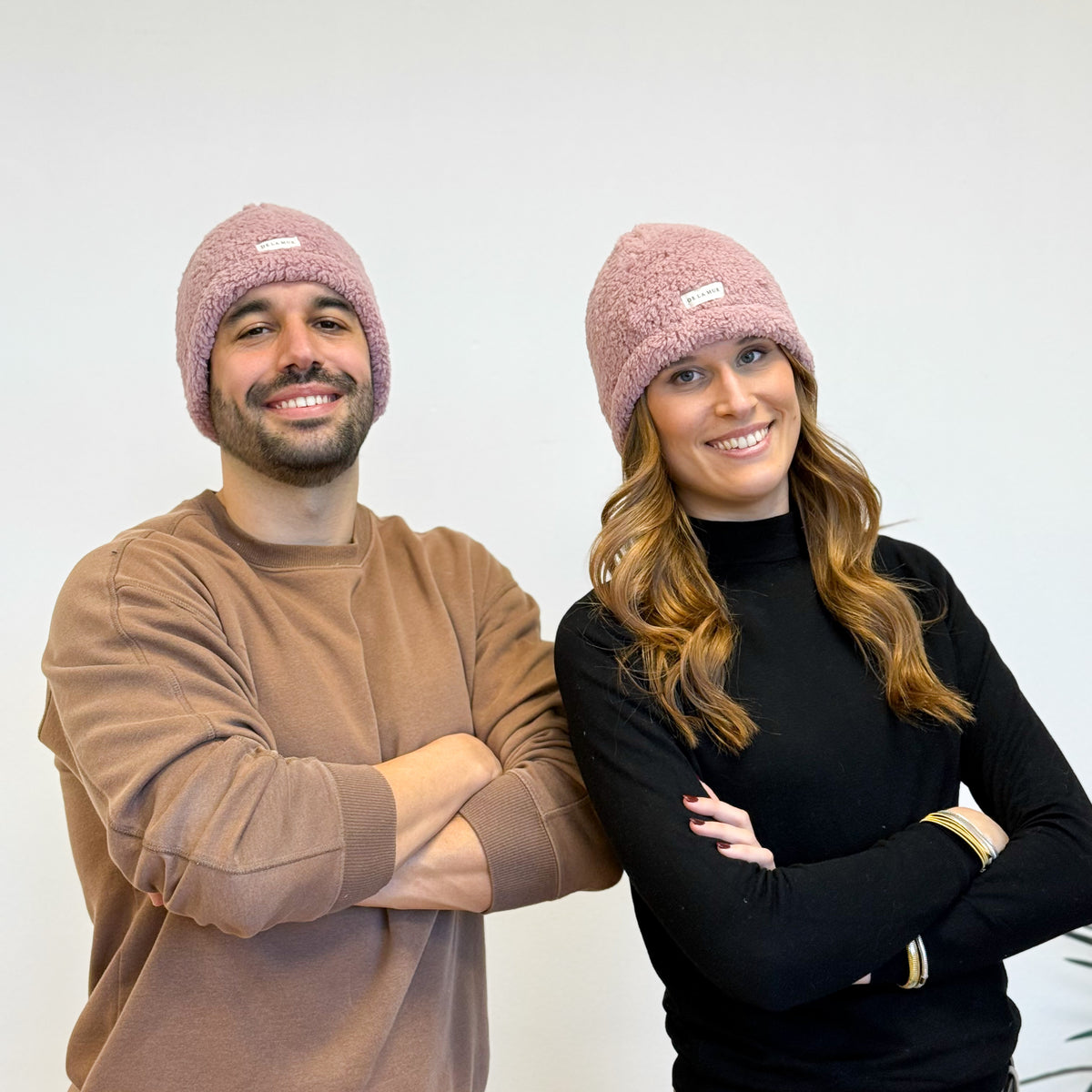 Two models wearing the DE LA MUR Sherpa Beanie in pink, lifestyle shot