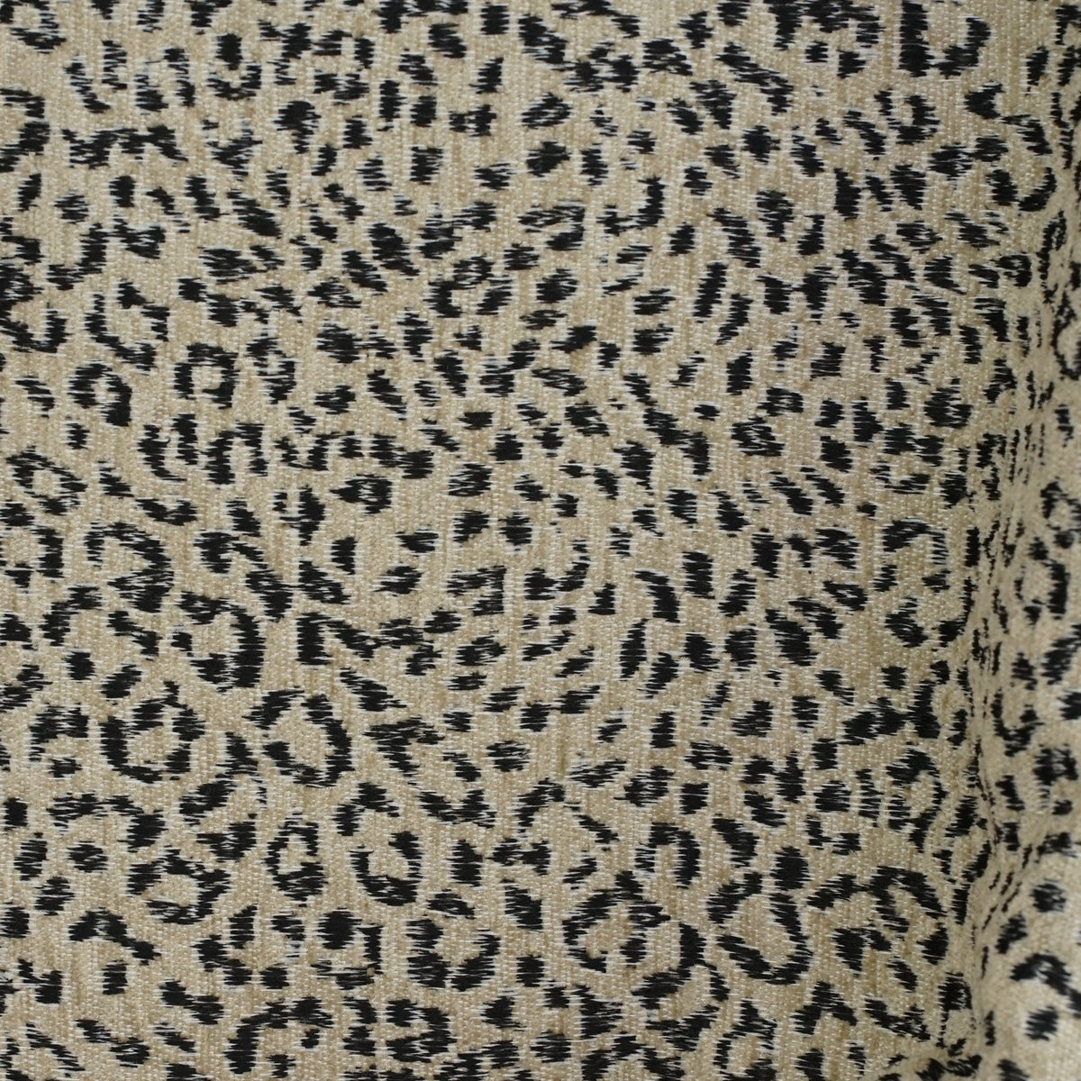 Close-up of the beige and black leopard jacquard fabric of DE LA MUR Koto bag