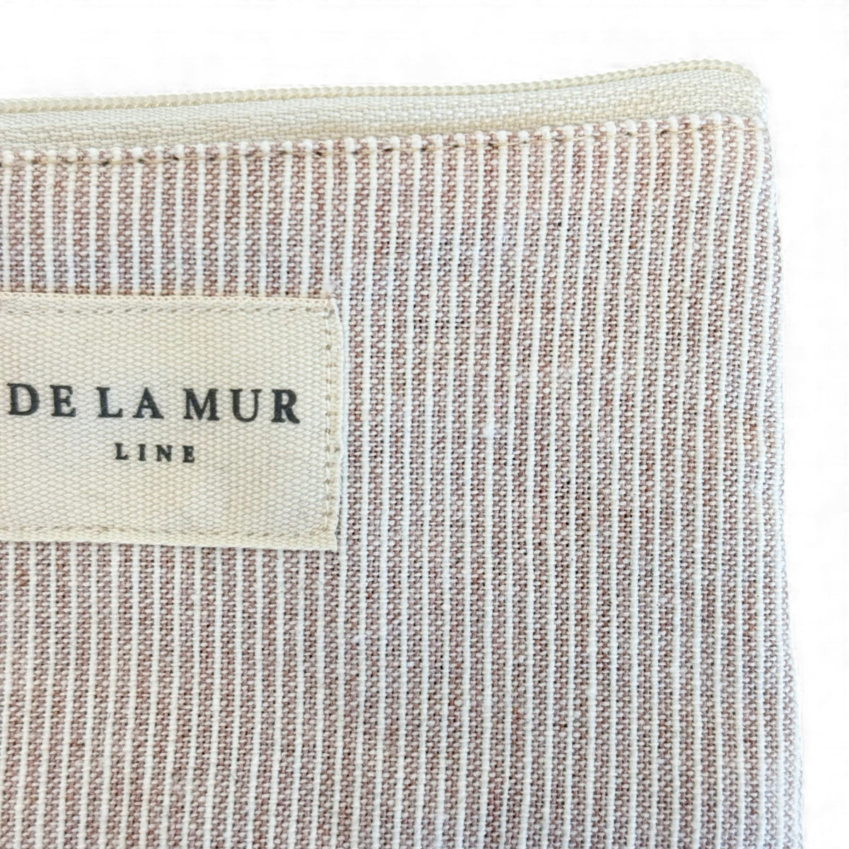 Close-up of the DE LA MUR Line label on the Ibi striped coin purse