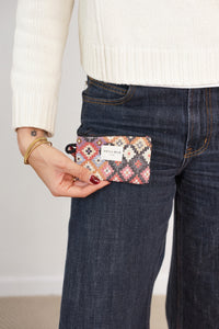 Model holding the DE LA MUR multicolor geometric jacquard coin purse at her pocket
