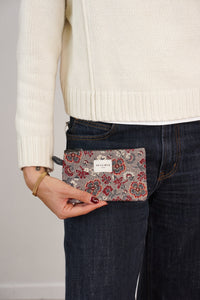 Model holding DE LA MUR burgundy floral jacquard coin purse at the hip, lifestyle shot