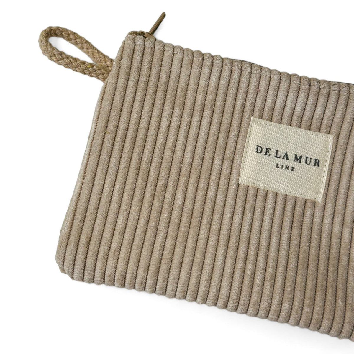 Detail of DE LA MUR makeup bag corduroy texture, zip and woven label