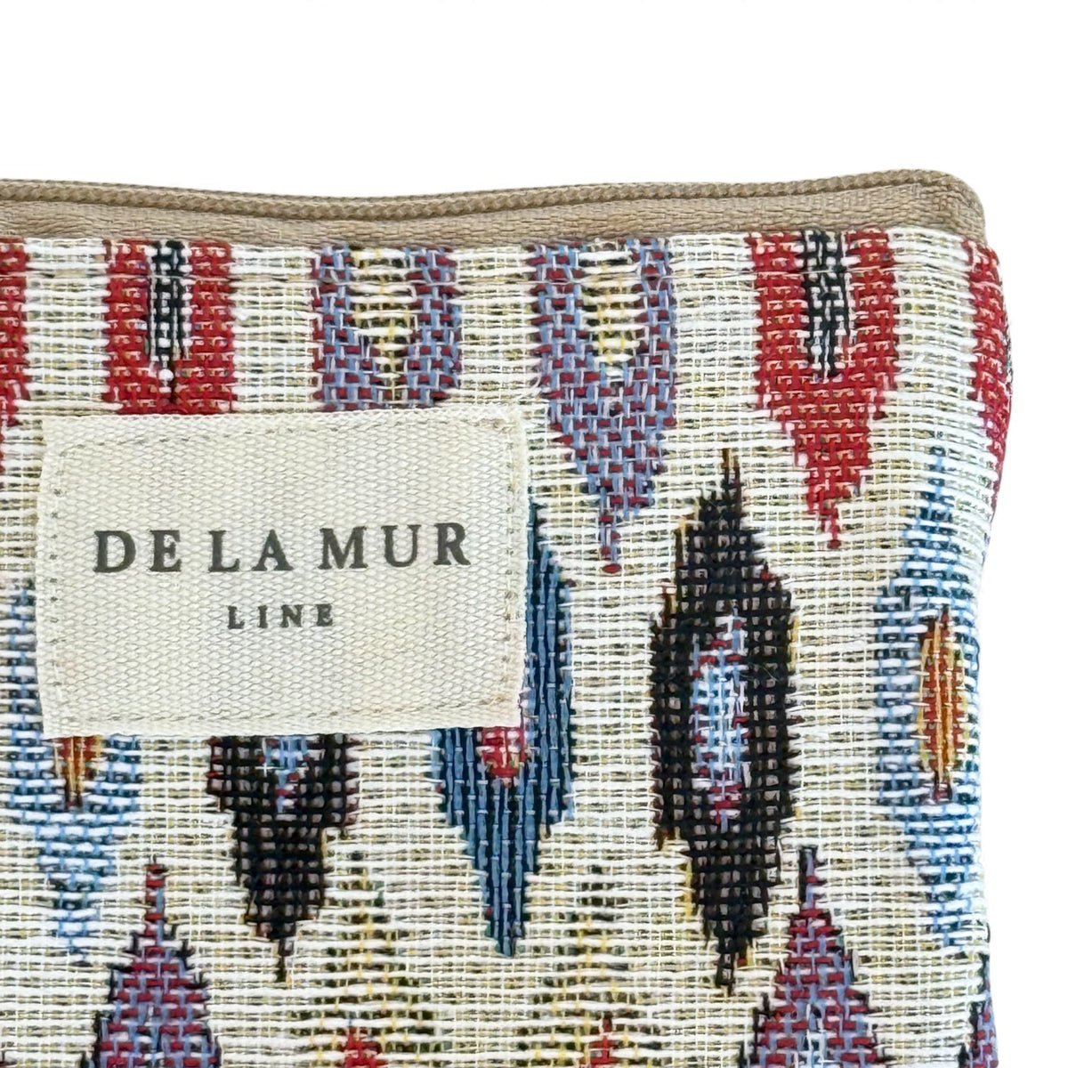 Close-up of DE LA MUR Line label on the Urban geometric jacquard makeup bag