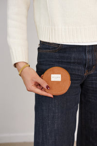 Model holding the terracotta corduroy DE LA MUR Barro round coin purse, lifestyle shot