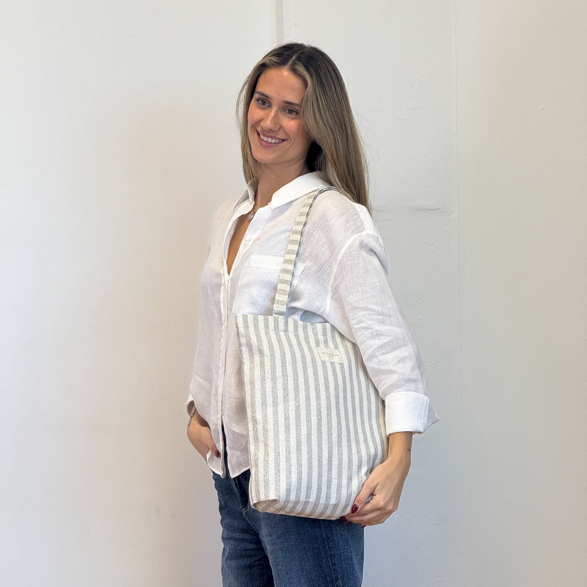 Model with the DE LA MUR Striped Medium Zippered Tote Bag – Ecru & Gray (Lugris)