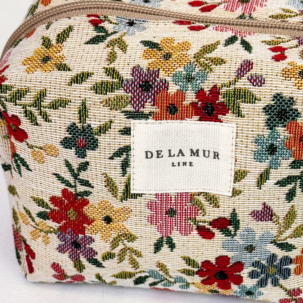 Close-up of the floral tapestry jacquard fabric and DE LA MUR Line label