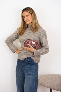 Model holding the DE LA MUR Chic geometric jacquard squared makeup bag