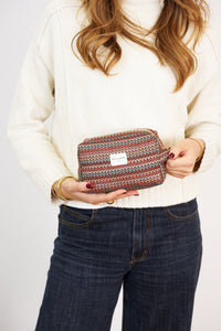 Model holding the DE LA MUR Fron zigzag jacquard squared makeup bag