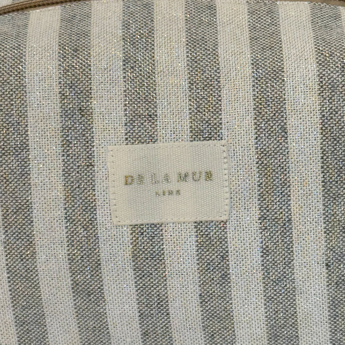 Close-up of the striped lurex fabric and DE LA MUR Line label, Lugris