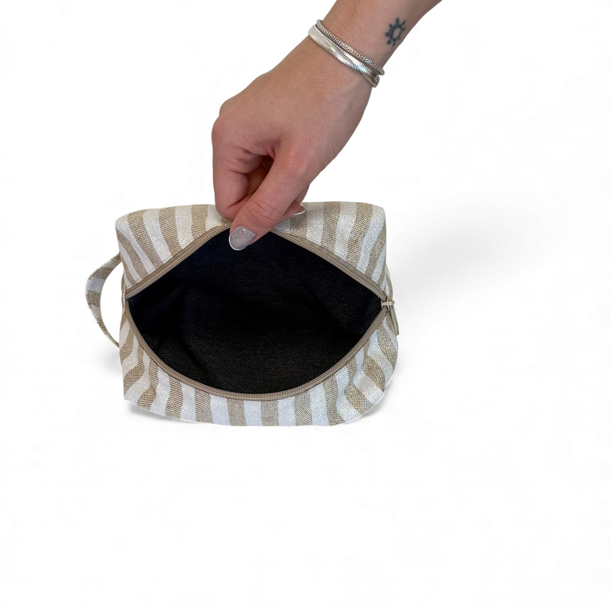 Open DE LA MUR Lumos striped makeup bag showing the dark interior