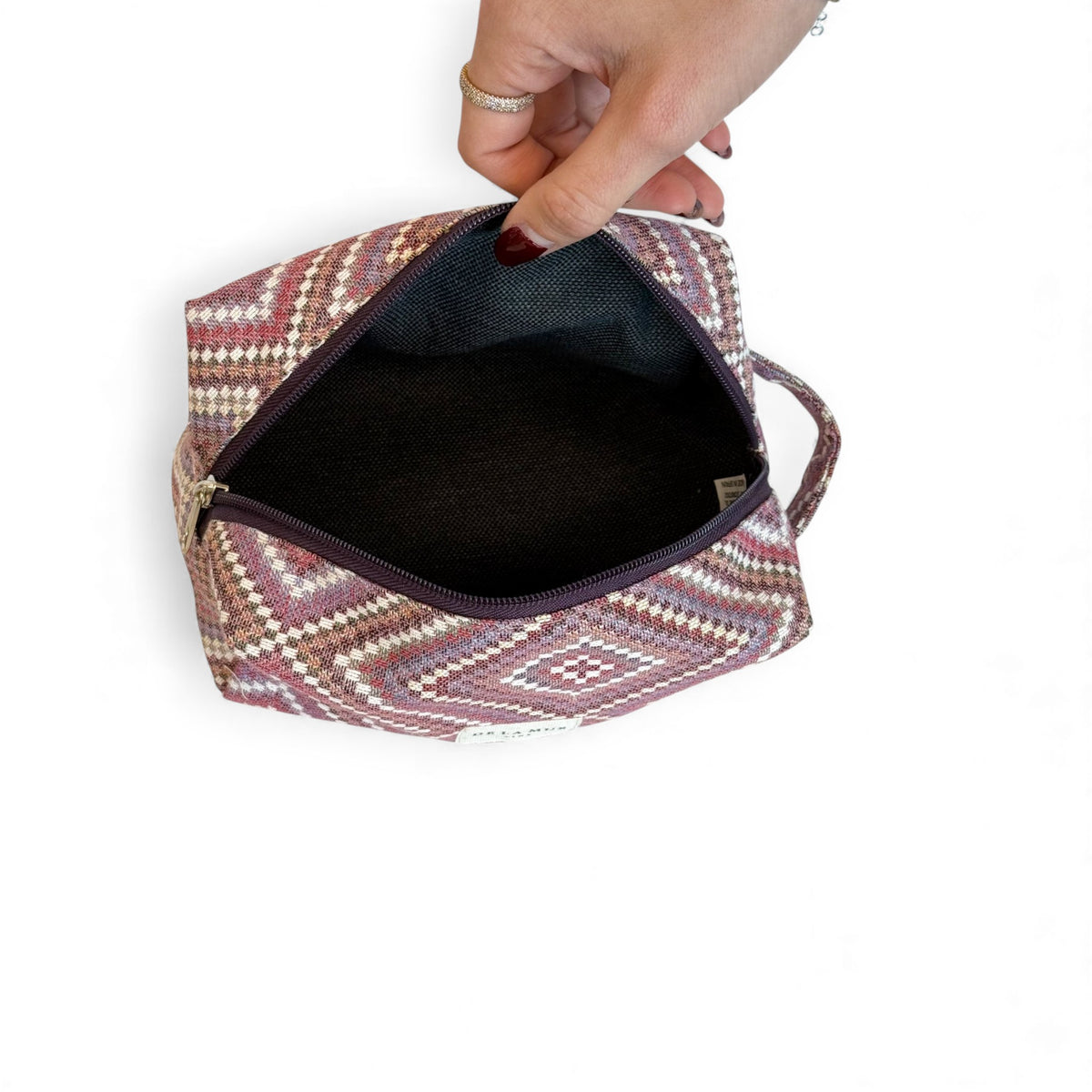 Open DE LA MUR Nana makeup bag showing the dark lined interior