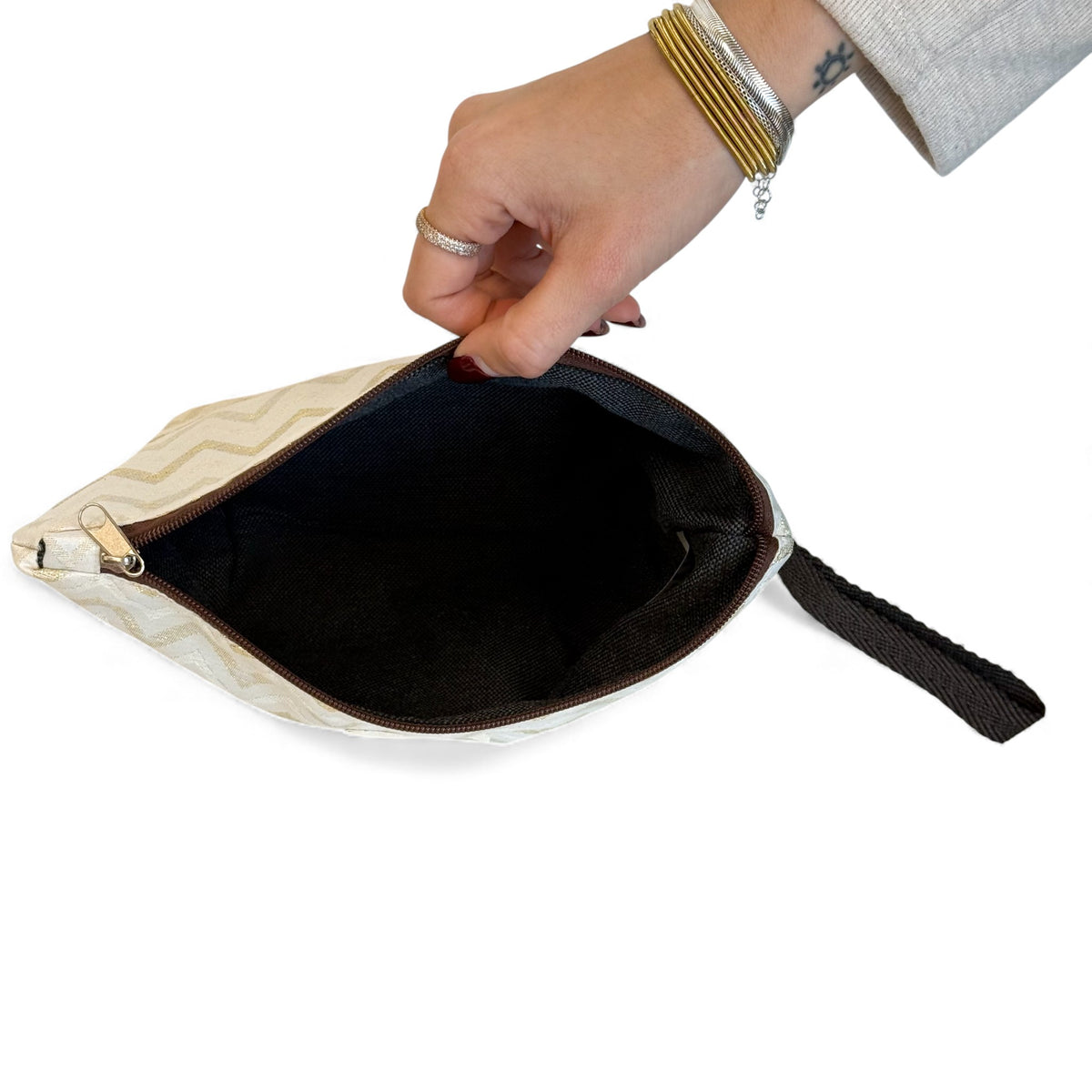 Open DE LA MUR Astro makeup bag showing the dark lined interior and wrist strap
