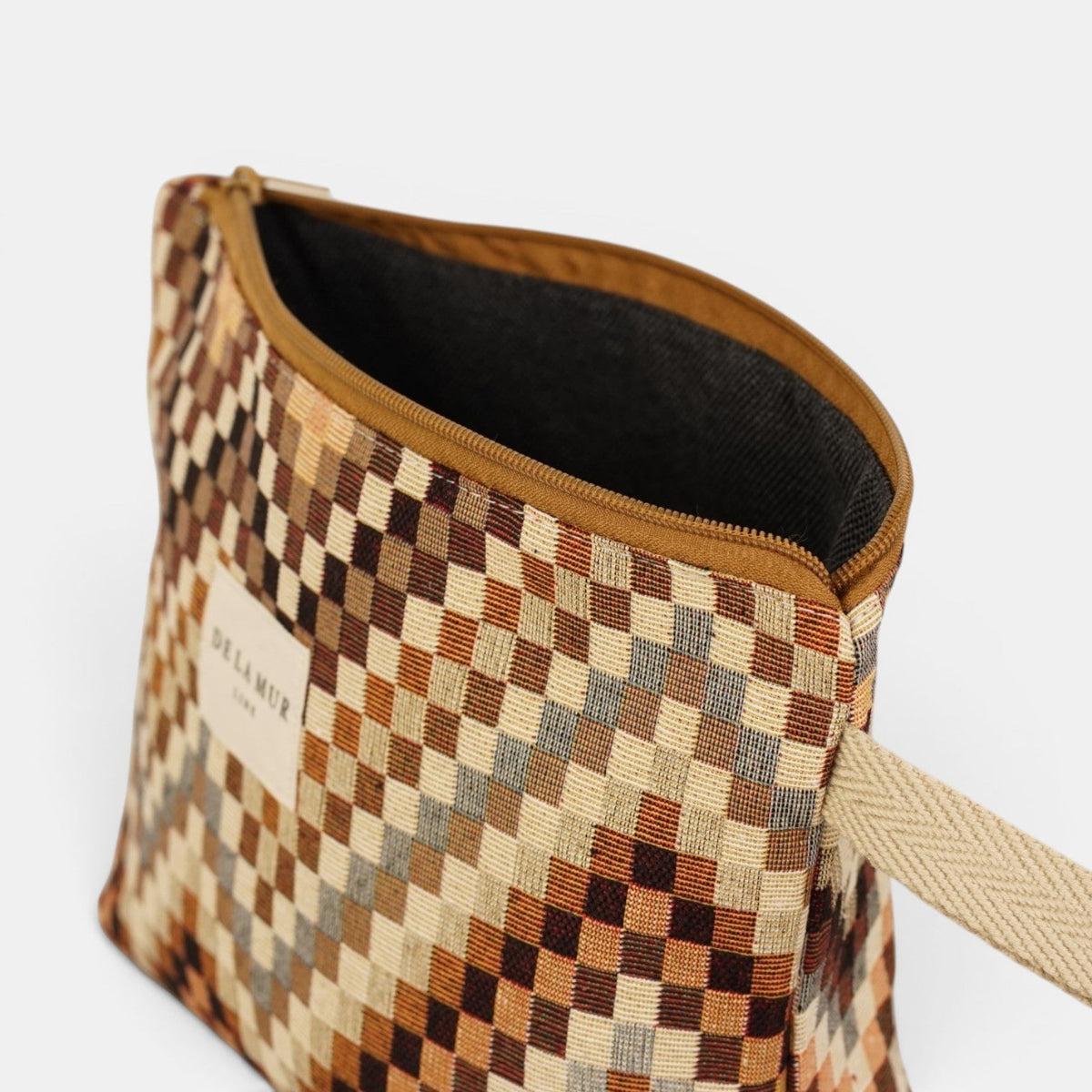Open DE LA MUR brown & beige makeup bag showing the dark lined interior