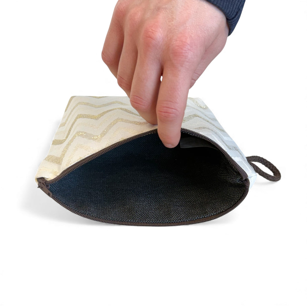 Open DE LA MUR zigzag makeup bag showing the dark lined interior