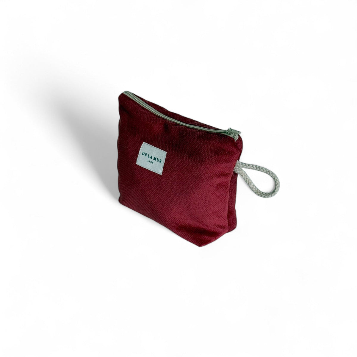 Three-quarter side view of the burgundy Bore velvet pouch