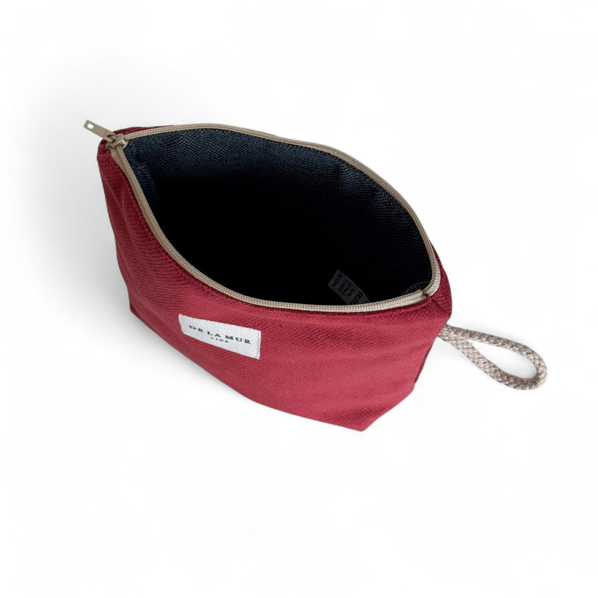 Open burgundy Bore makeup bag showing the dark lined interior