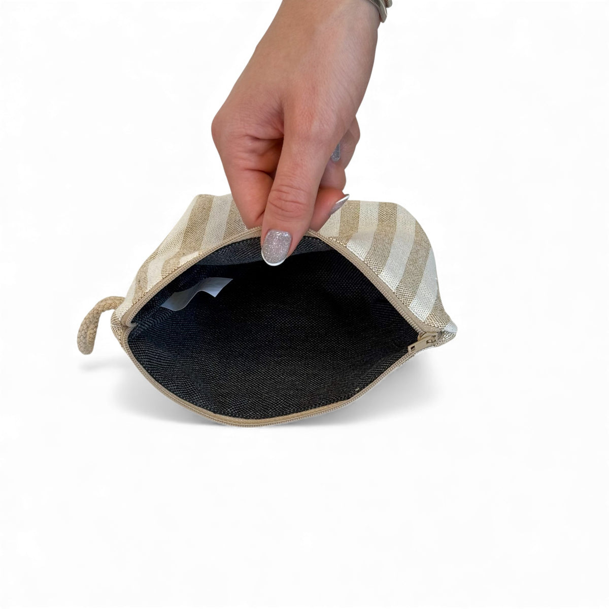 Open DE LA MUR Lumos makeup bag showing the dark lined interior and zip