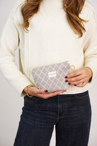 Woman holding the DE LA MUR Pant gingham jacquard small makeup bag