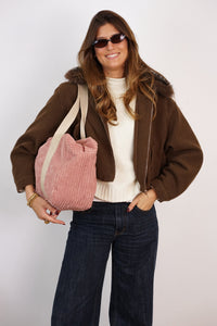 Model carrying the DE LA MUR dusty rose corduroy Sports Bag (Crepe) on the shoulder, lifestyle shot