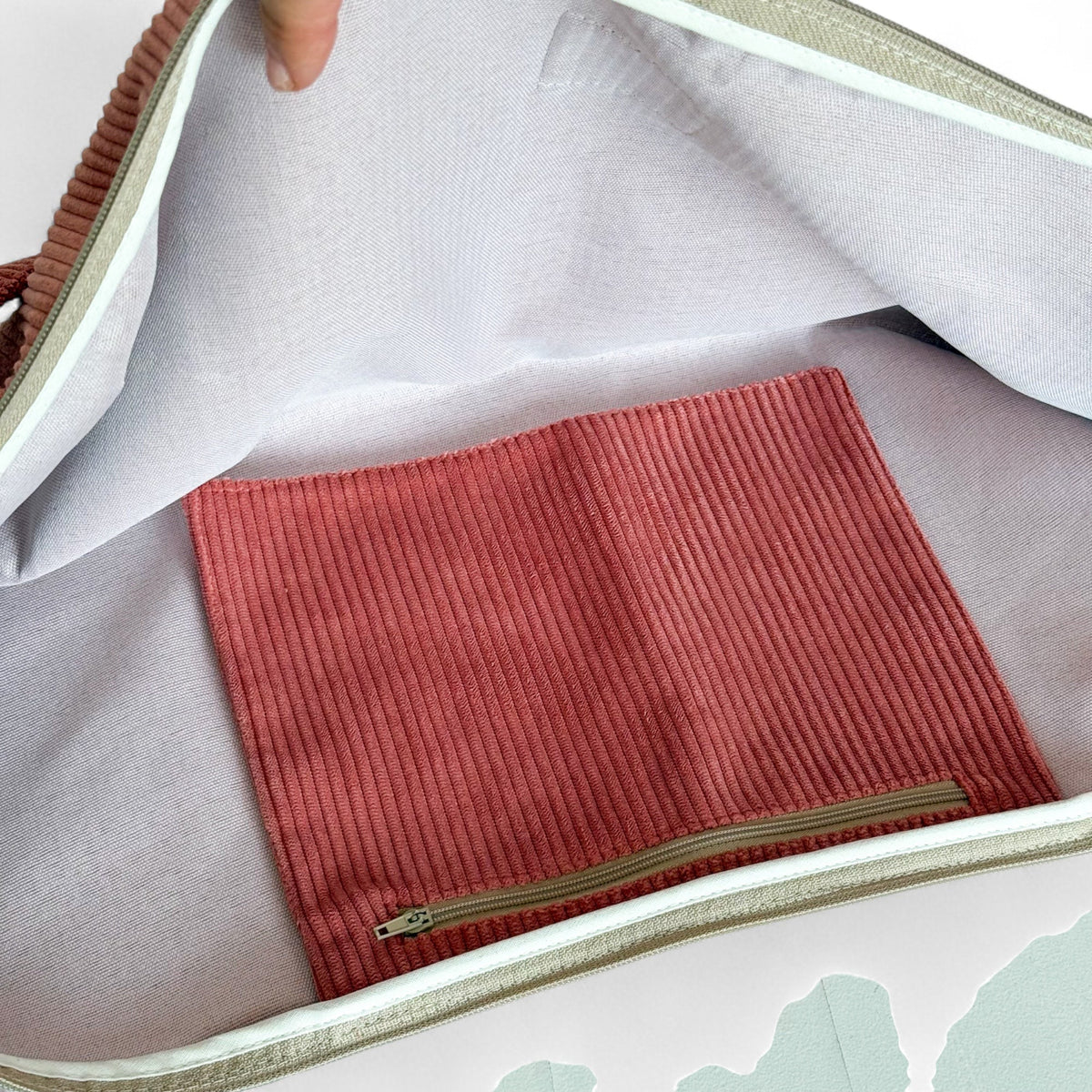 Open DE LA MUR coral corduroy yoga mat bag showing the inner zip pocket and lining