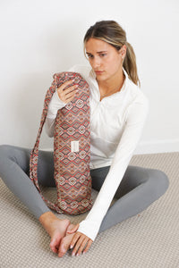 Model holding DE LA MUR Otto geometric jacquard yoga mat bag in red multicolor, lifestyle shot